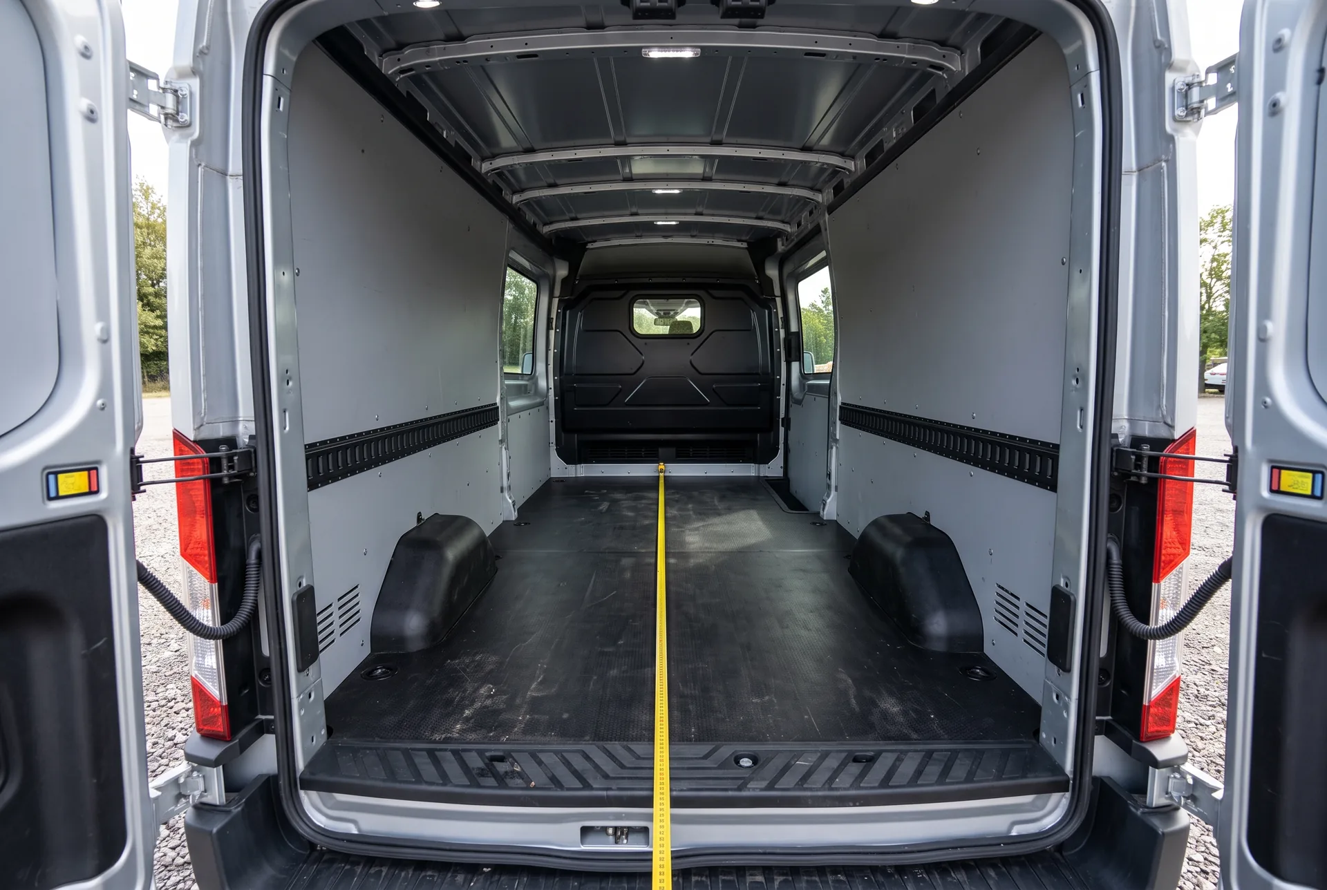 Leerer Laderaum des Ford Transit mit ausgebauten Sitzreihen und Maßband — 3,50 m Ladelänge